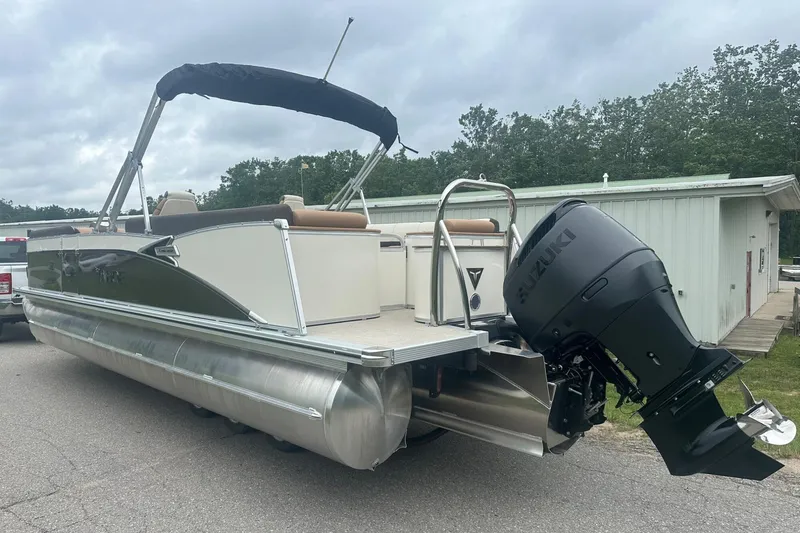 Slide: The Image of 2025 Tahoe 2585 pontoon boat with Suzuki outboard motor on a paved surface. - 4