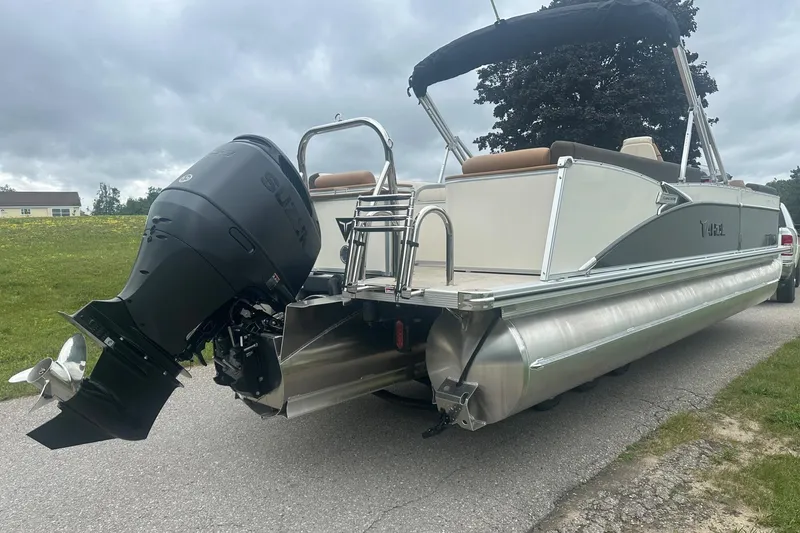 Slide: The Image of 2025 Tahoe 2585 pontoon boat with outboard motor on a cloudy day. - 7