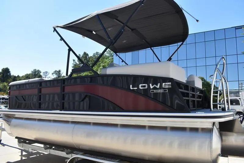Slide: The Image of 2026 Lowe SS 210 WT pontoon boat with canopy, parked outdoors. - 6