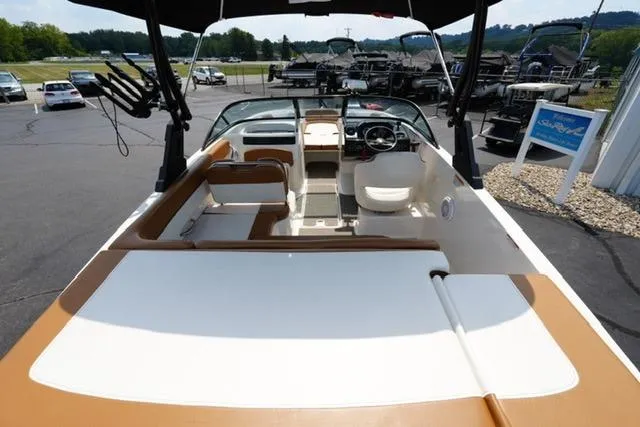 Slide: The Image of 2019 Bayliner VR5 Bowrider I/O boat interior with seating and steering wheel, parked outdoors. - 7