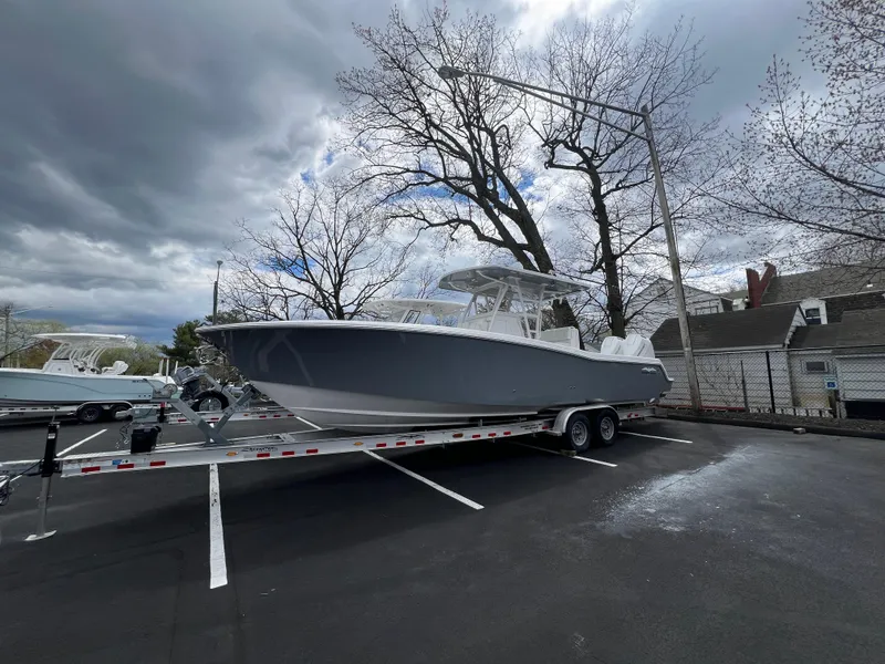 Slide: The Image of 2024 Invincible 33 Open Fisherman boat on a trailer in a parking lot. - 2