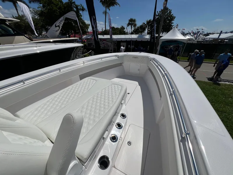 Slide: The Image of 2024 Invincible 33 Open Fisherman boat with white seating at a boat show. - 6