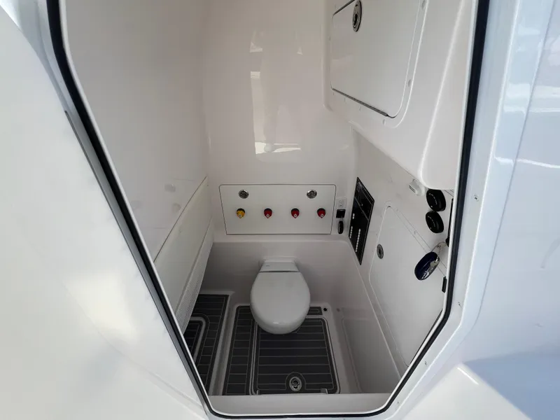 Slide: The Image of 2024 Invincible 33 Open Fisherman boat interior bathroom with toilet and control panel. - 8