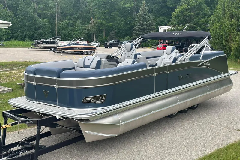 Slide: The Image of 2025 Tahoe 2585 pontoon boat on trailer, parked in a scenic outdoor setting. - 3