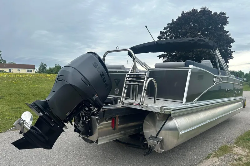 Slide: The Image of 2025 Tahoe 2585 pontoon boat with Suzuki outboard motor on a road. - 8