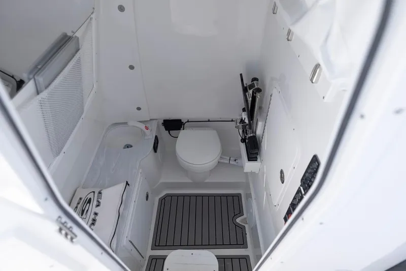 Slide: The Image of Interior of 2026 Sea Hunt Gamefish 28 boat, featuring a compact marine toilet. - 15