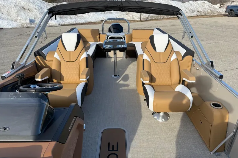 Slide: The Image of Luxurious 2025 Tahoe 2585 boat interior with tan and white seating, steering wheel, and cup holders. - 13