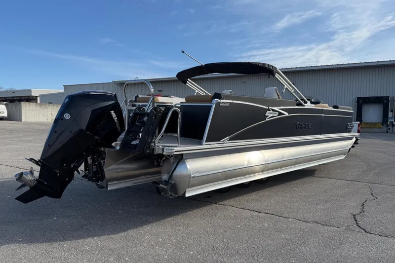 Slide: The Image of 2025 Tahoe 2585 pontoon boat with Mercury outboard engine, parked outdoors. - 4