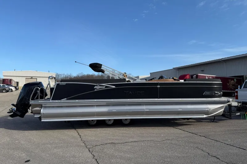 Slide: The Image of 2025 Tahoe 2585 pontoon boat parked outdoors under clear blue sky. - 5