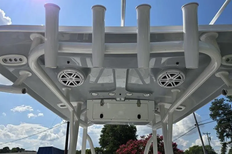 Slide: The Image of 2026 Sea Hunt BX 22 BR boat T-top with rod holders and speakers under a sunny sky. - 12