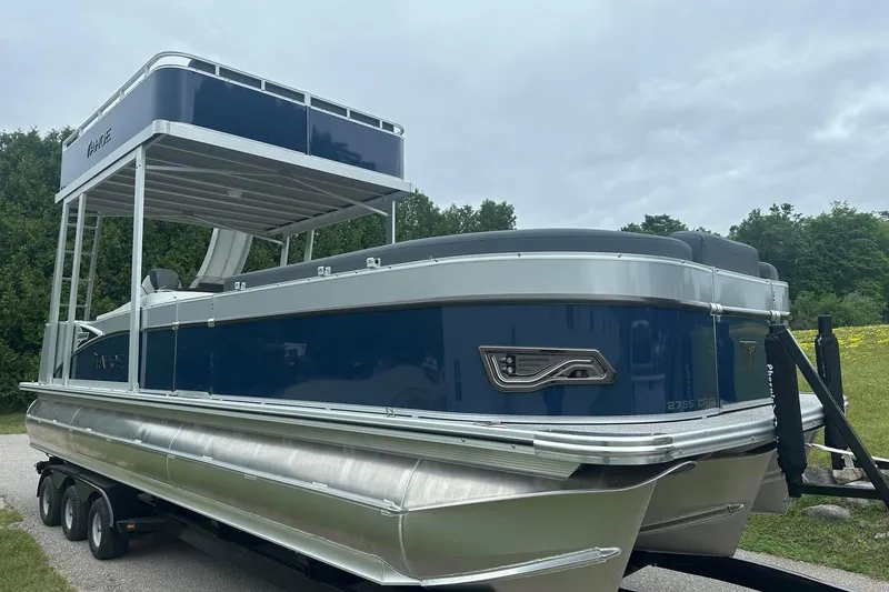 Slide: The Image of 2025 Tahoe 2585 pontoon boat with upper deck, parked on a trailer. - 10