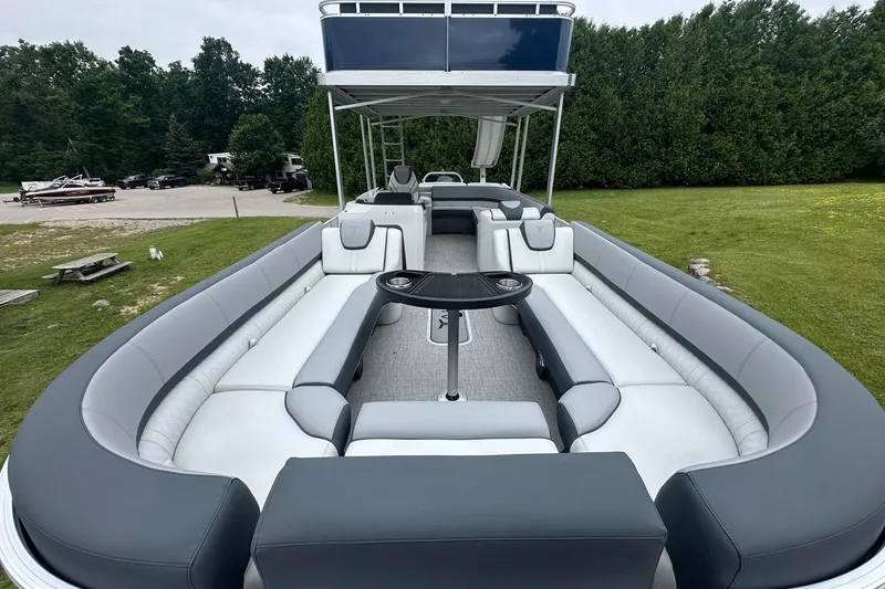 Slide: The Image of 2025 Tahoe 2585 pontoon boat with spacious seating and sleek design, parked on grass. - 11