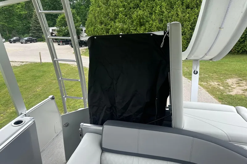 Slide: The Image of 2025 Tahoe 2585 boat interior with seating, ladder, and privacy curtain. - 29