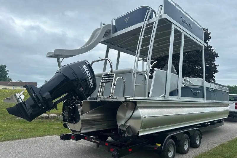 Slide: The Image of 2025 Tahoe 2585 pontoon boat with slide and Suzuki outboard motor on trailer. - 8