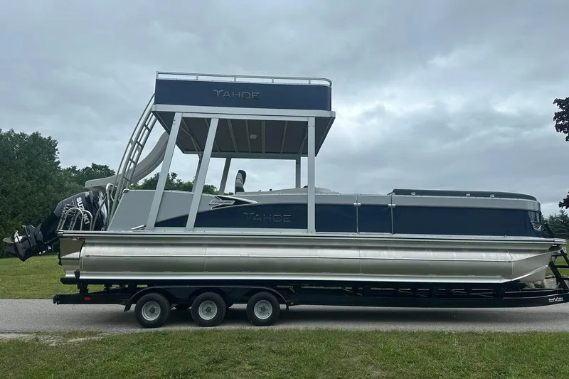 Slide: The Image of 2025 Tahoe 2585 pontoon boat on trailer, featuring upper deck and Suzuki outboard motor. - 9