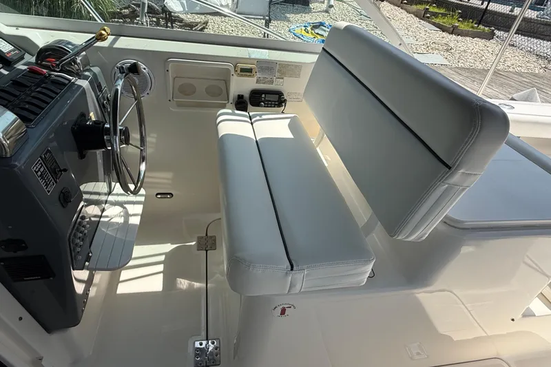 Slide: The Image of 1999 Tiara Yachts 2900 Coronet helm with steering wheel and cushioned seating. - 11