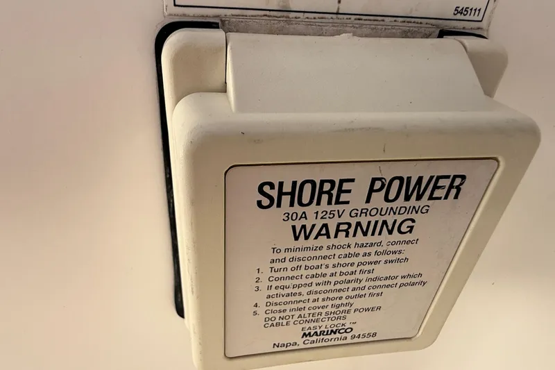 Slide: The Image of Shore power warning label on 1999 Tiara Yachts 2900 Coronet, 30A 125V grounding instructions. - 19
