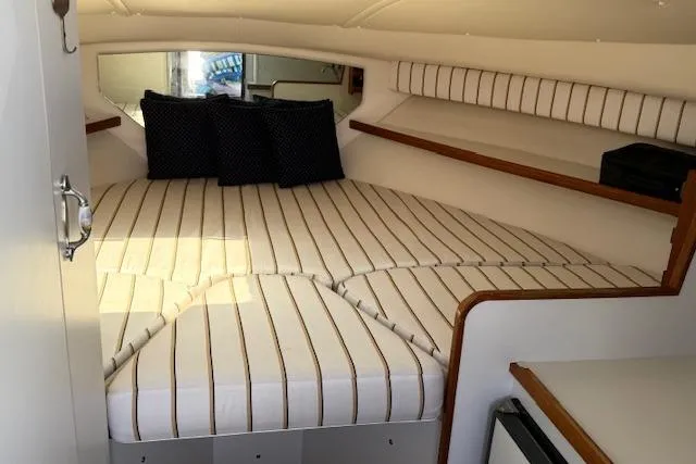 Slide: The Image of 1999 Tiara Yachts 2900 Coronet cabin with striped bedding and cushions. - 25