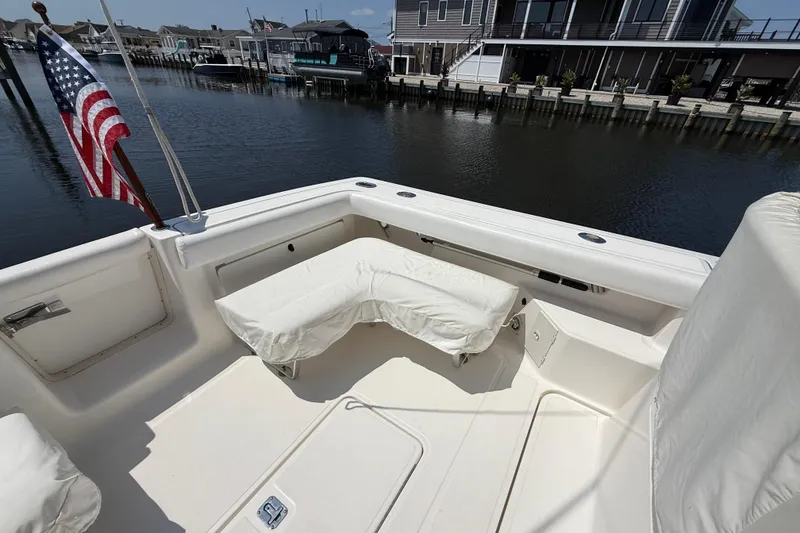 Slide: The Image of 1999 Tiara Yachts 2900 Coronet boat deck with seating, docked by waterfront homes. - 3