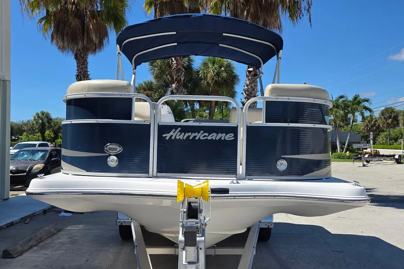 Slide: The Image of 2014 Hurricane FunDeck 216 OB boat on trailer, surrounded by palm trees. - 5