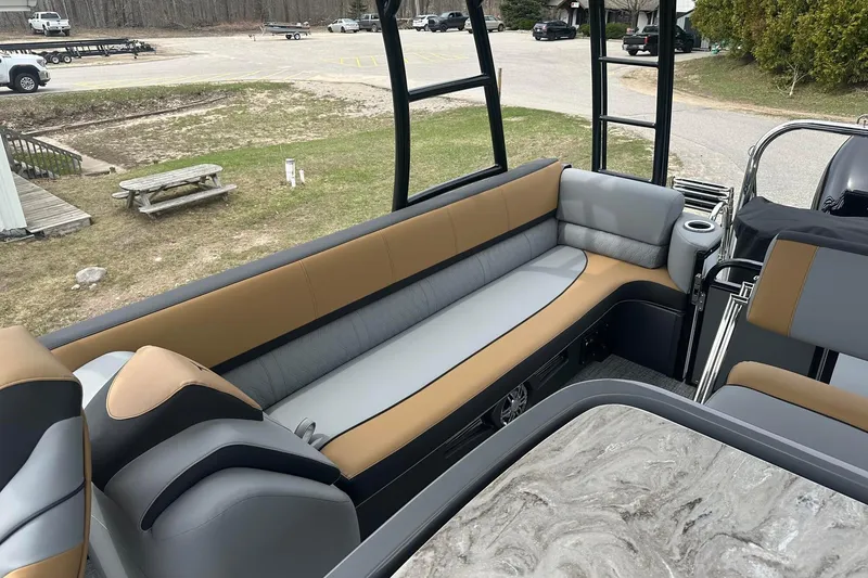 Slide: The Image of 2025 Tahoe 2785 boat interior with tan and gray seating, marble-patterned table, and outdoor setting. - 12