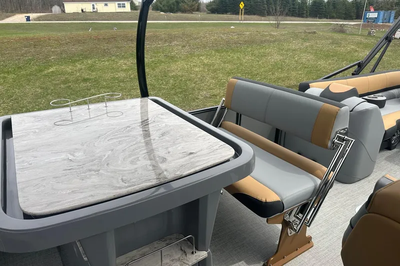 Slide: The Image of 2025 Tahoe 2785 boat interior with modern seating and marble-style table. - 13