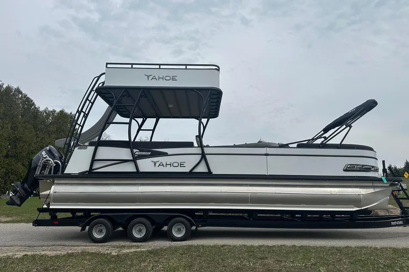 Slide: The Image of 2025 Tahoe 2785 pontoon boat on trailer, side view, outdoors. - 7