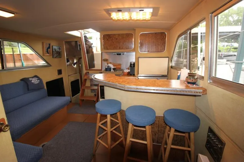 Slide: The Image of 1983 Chris-Craft 350 Catalina interior with bar, stools, and seating area. - 12
