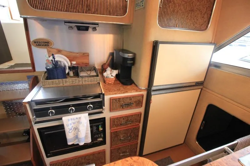 Slide: The Image of 1983 Chris-Craft 350 Catalina kitchen with stove, fridge, and coffee maker. Cozy nautical interior. - 13