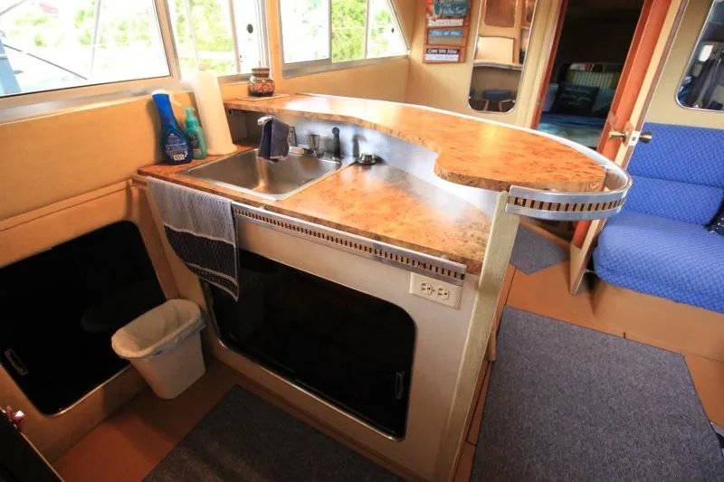 Slide: The Image of 1983 Chris-Craft 350 Catalina kitchen area with sink, countertop, and seating. - 14