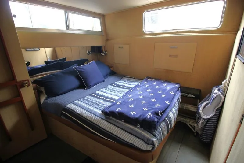 Slide: The Image of 1983 Chris-Craft 350 Catalina cabin interior with cozy bed and nautical decor. - 15
