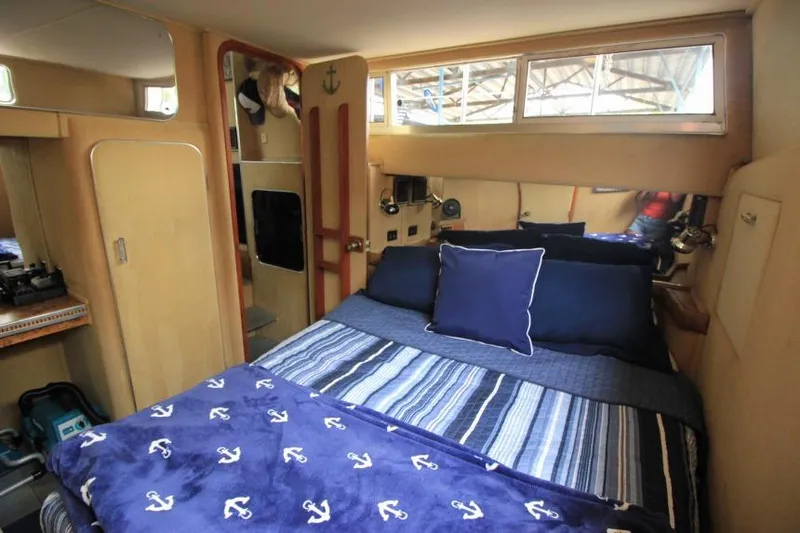 Slide: The Image of 1983 Chris-Craft 350 Catalina cabin interior with nautical-themed bedding and cozy decor. - 16