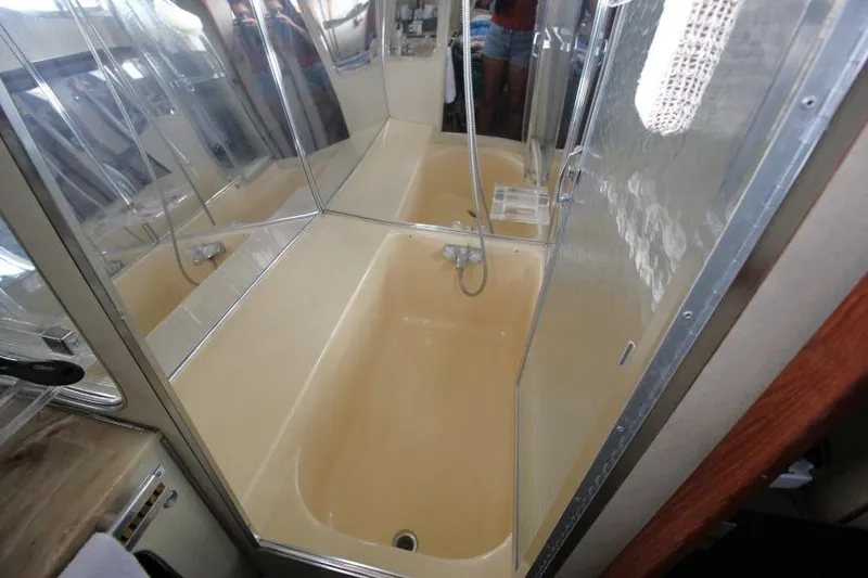 Slide: The Image of 1983 Chris-Craft 350 Catalina bathroom with beige bathtub and shower fixtures. - 20