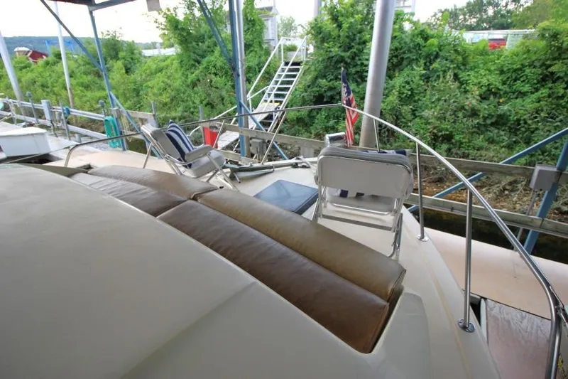 Slide: The Image of 1983 Chris-Craft 350 Catalina yacht deck with seating, docked near lush greenery. - 26