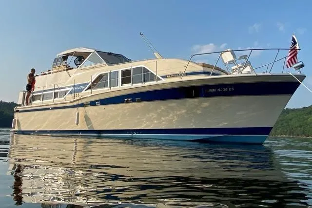 Slide: The Image of 1983 Chris-Craft 350 Catalina yacht on calm water, featuring classic design and American flag. - 28