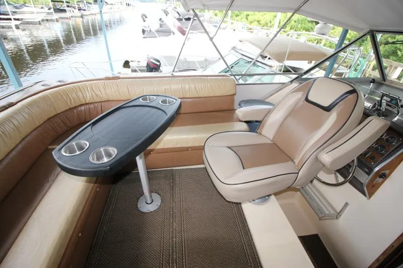 Slide: The Image of 1983 Chris-Craft 350 Catalina interior with beige seating and black table, docked at marina. - 5