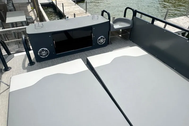 Slide: The Image of 2025 Tahoe 2785 boat interior with cushioned seating and modern audio system at dock. - 23