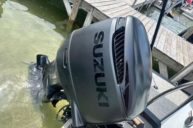 Slide: The Image of Outboard motor on a 2025 Tahoe 2785 boat, docked in clear water. - 24