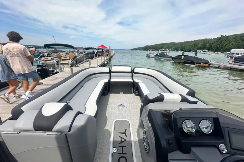 Slide: The Image of 2025 Tahoe 2785 boat docked at a scenic lake with people walking nearby. - 4