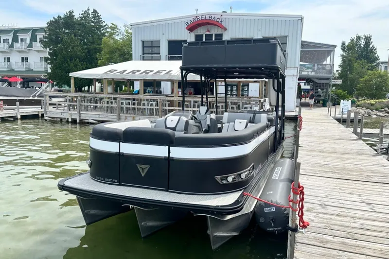 Slide: The Image of 2025 Tahoe 2785 pontoon boat docked at a lakeside restaurant. - 9