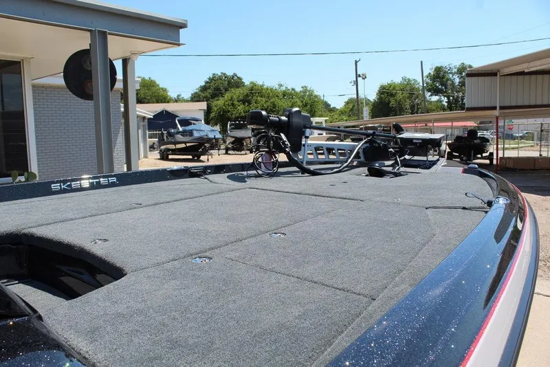 Slide: The Image of 2026 Skeeter ZXE21 boat deck with equipment, parked outdoors on a sunny day. - 17