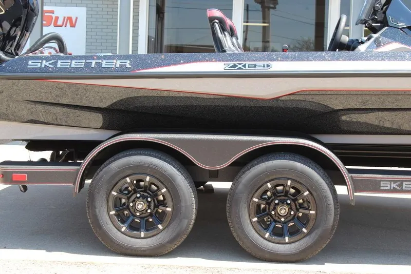 Slide: The Image of 2026 Skeeter ZXE21 boat on a trailer, showcasing sleek design and dual wheels. - 7