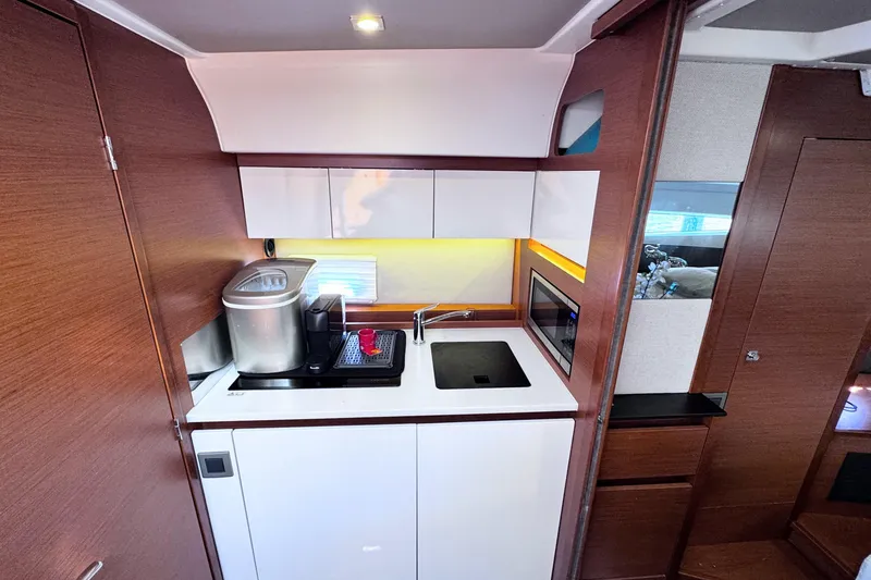 Slide: The Image of Modern kitchen area in a 2016 Jeanneau Leader 36 yacht, featuring sleek cabinetry and appliances. - 12
