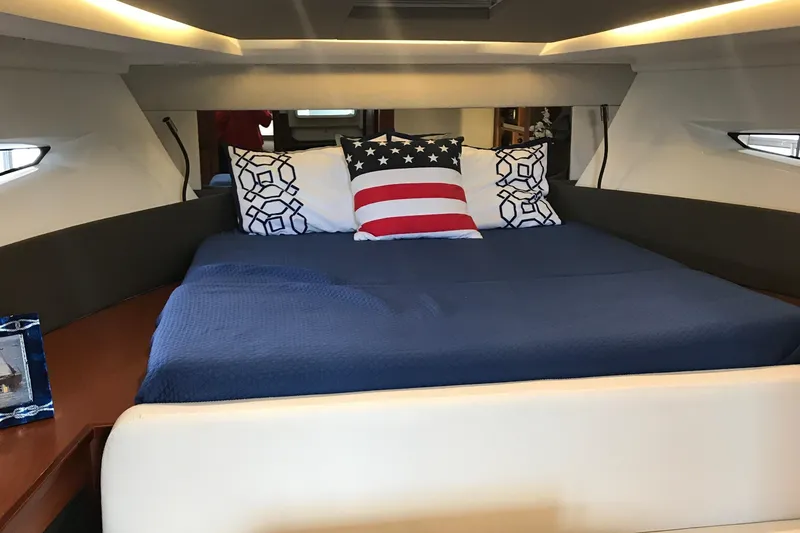 Slide: The Image of Cozy cabin interior of 2016 Jeanneau Leader 36 with blue bedding and decorative pillows. - 15