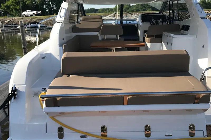 Slide: The Image of 2016 Jeanneau Leader 36 boat interior with beige seating and wooden table. - 16