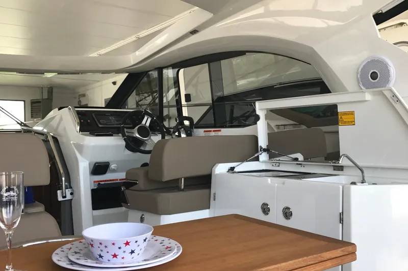 Slide: The Image of 2016 Jeanneau Leader 36 interior with helm, seating, and dining area. - 18
