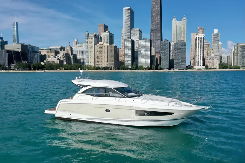 Slide: The Image of 2016 Jeanneau Leader 36 yacht on blue water with city skyline backdrop. - 4