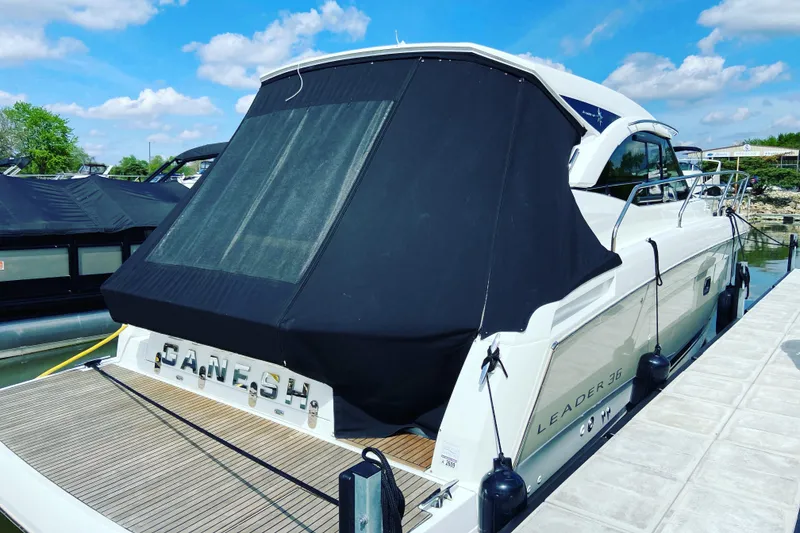 Slide: The Image of 2016 Jeanneau Leader 36 yacht docked with black cover, sunny day. - 6