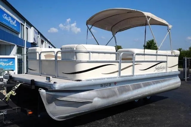 Slide: The Image of 2007 Godfrey 200 Sweetwater pontoon boat with canopy, parked outdoors on a sunny day. - 2