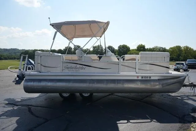 Slide: The Image of 2007 Godfrey 200 Sweetwater pontoon boat with canopy on a trailer, parked outdoors. - 4